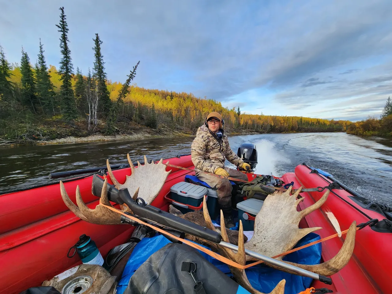 A man in a boat with antlers on the back of it.