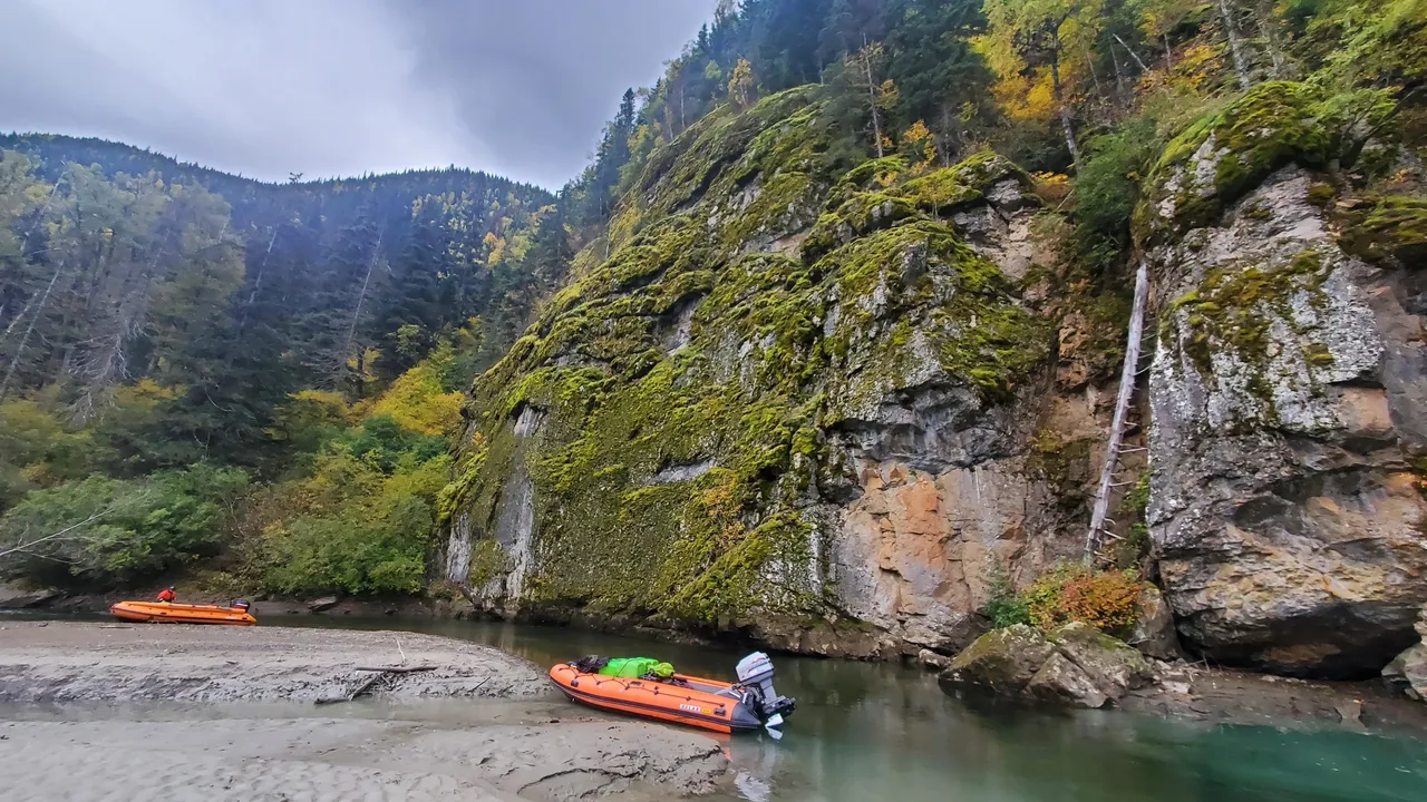 A man in an orange raft on the river.