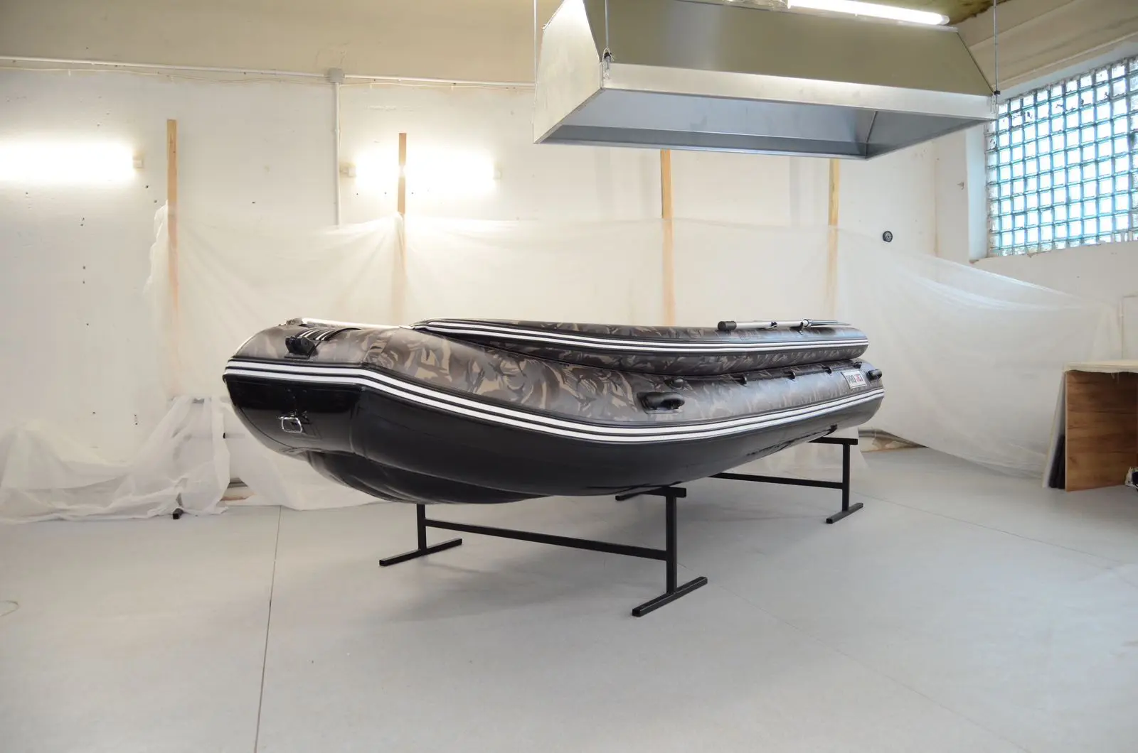 A boat on display in an empty room.