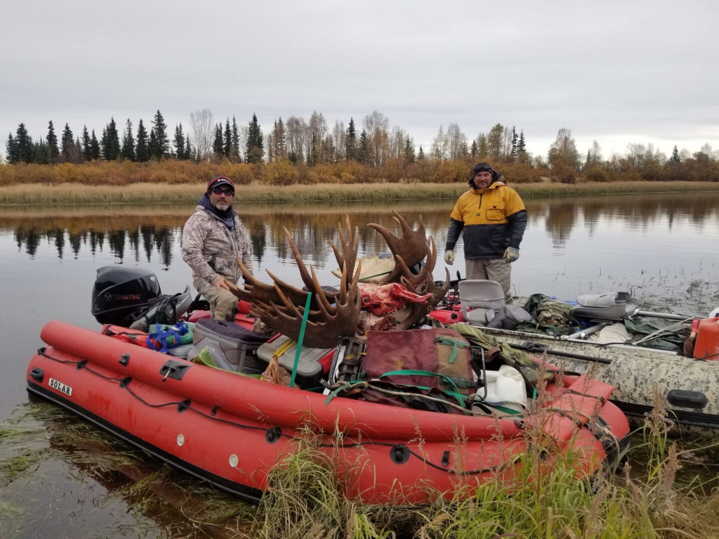 Two men in a raft with fishing gear.