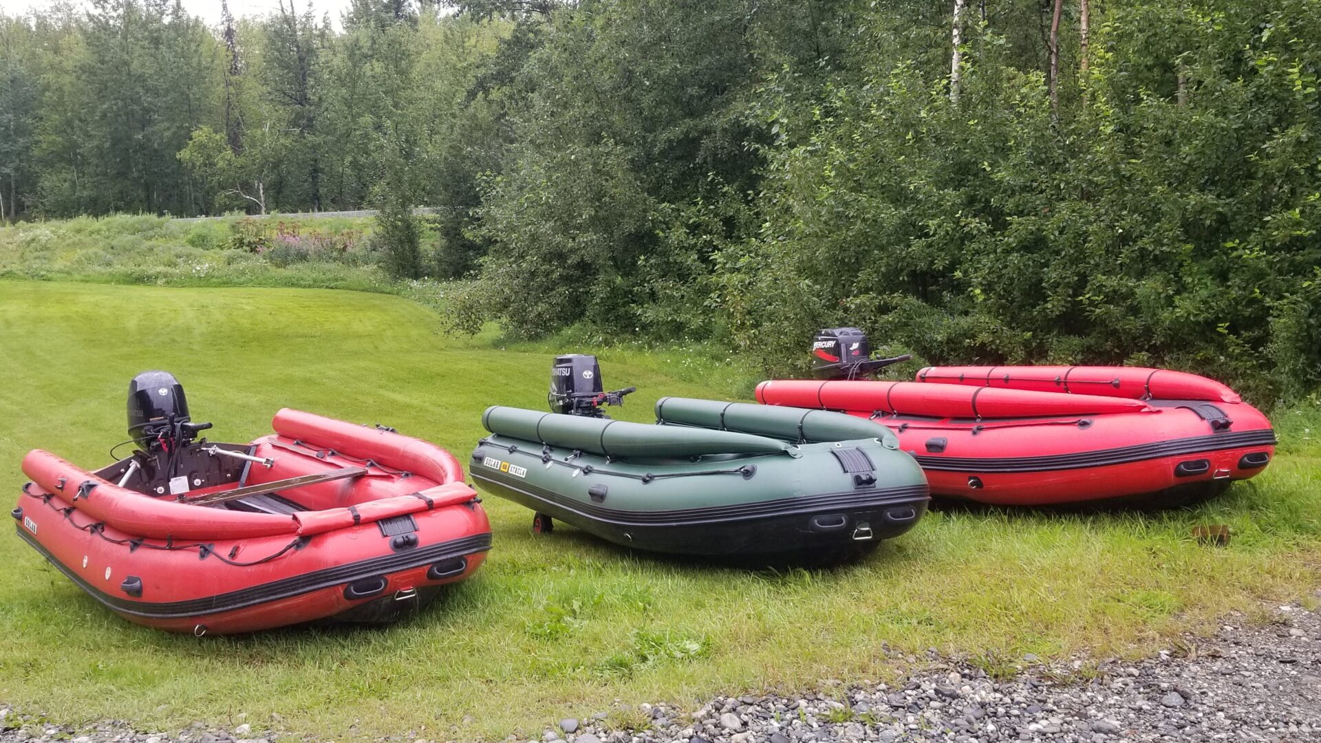 A group of boats sitting on top of a grass covered field.