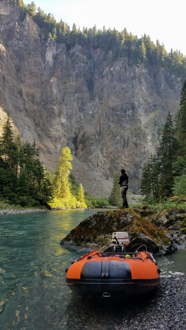 A man standing on the side of a river.